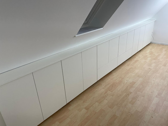 Weißer Einbauschrank unter Dachschräge mit Lichtleiste